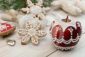Christmas New Year decoration. Painted red apple with sugar icing, gingerbread cookies.