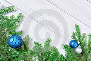 Christmas or new year decorations background: tree branches and blue Christmas toys in the form of balls. Flat lay. Copy space