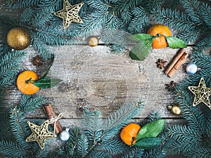 Christmas (New Year) decorations: fur-tree branches, golden glass balls, golden glittering toy stars, fresh mandarins, cinnamon s