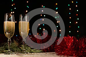Christmas and New Year dinner of a couple with two glasses of champagne. The concept of the celebration. Pearls, tinsel and spruce
