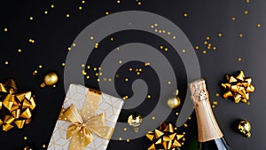 Christmas or New Year Eve celebration concept. Luxury Christmas composition with champagne bottle, gift box, golden decorations,