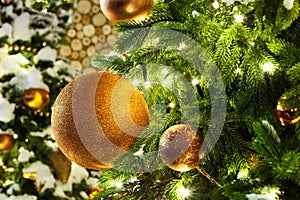 Christmas or New Year festive banner, golden christmas decorations glass balls, green pine branches, white snow and shiny lights