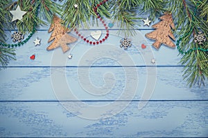 Christmas or New Year flat lay: pine branches with some decorations and necklaces on the blue boards