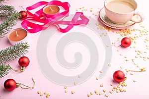 Christmas or New Year frame composition. Decorations, red balls, fir and spruce branches, on a pink background. Side view, copy