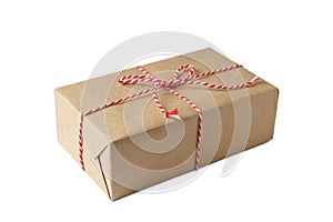 Christmas and New Year gift box wrapped in brown craft kraft paper with red and white baker's twine