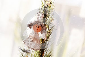 Christmas, New Year holiday background. Top of decorated christmas tree with little toy princess on the bright window background.