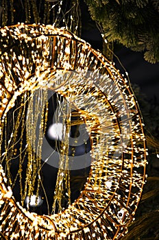 Christmas New Year holiday illumination. Glowing round golden garland on the background of the Christmas tree at night