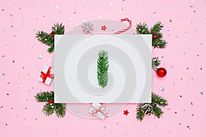 Christmas, New Year holiday layout. Natural fir tree branche in frame of decorations on white and pastel pink flat lay