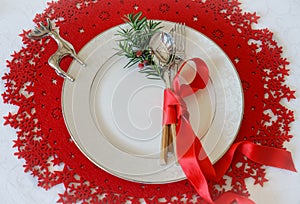 Christmas And New Year Holiday Table Place Setting with branch of Christmas tree and silver deer. Top view, red woolen and white