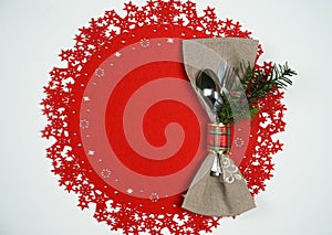 Christmas And New Year Holiday Table Place Setting with branch of Christmas tree. Top view, red woolen and white background.