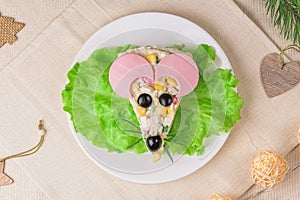 Christmas New Year menu idea - salad looks like a rat mouse on a white plate in a festive scene. Edible mice with ham ears