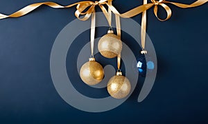 Golden and blue Glass Balls hanging on ribbon on Navy blue background with copy space for text