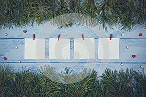 Christmas or New Year mock up: pine branches and white stickers with little clothespins on the blue boards