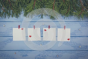 Christmas or New Year mock up: pine branches, white stickers with red clothespins and wooden decorative hearts and stars on the