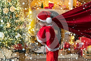 For Christmas and New Year posters. Funny little Santa Claus with huge red bag with presents. Santa child. Boy child