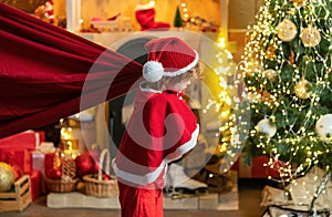 For Christmas and New Year posters. Funny little Santa Claus with huge red bag with presents. Santa child. Boy child