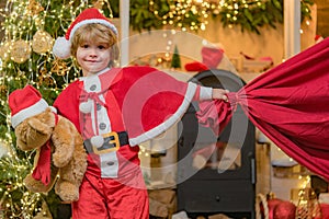 For Christmas and New Year posters. Santa child. Santa helper holding a red bag with presents. Little Santa Claus