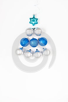 Christmas or New Year`s composition 2021. Beautiful xmas tree made of blue and silver decorations on a white background and copy