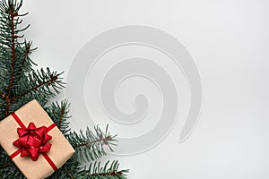 Christmas or New Year`s composition with a gift box and Christmas tree branches on white background. Copy space, flat