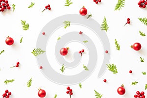 Top view of spruce branches, pine cones, red berries and bell on white background.