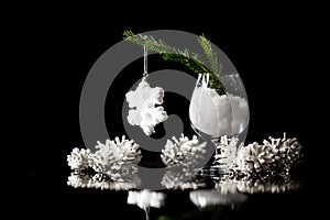 Christmas and New Year`s snow decorations on a black mirror reflection surface and dark bokeh lights background. Card template w