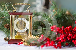 Christmas and New Year's still-life with a coach for hours, red berries and spruce branches,