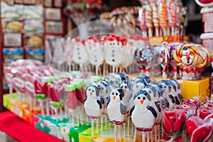 Christmas and New year`s street fair sweet food. Snowman shaped candies, lollypops and candy canes in shop