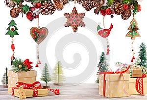 Christmas or New Year scene with gift boxes and garland of fir branches, red berries, pine cones and other wooden ornaments