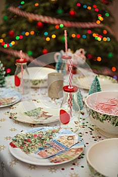 Christmas and New Year table place setting with empty Christmas plates with festive decorations bauble snowflake star bow ball pi