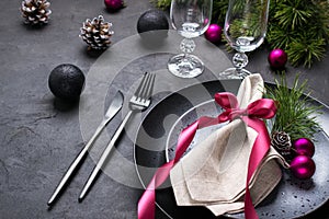 Christmas or New Year table setting with christmas pine branches, holiday decorations knife, fork ,ribbon and plate. Menu concept