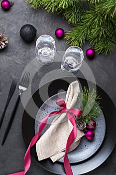 Christmas or New Year table setting with christmas pine branches, holiday decorations knife, fork ,ribbon and plate. Menu concept