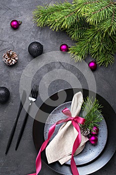 Christmas or New Year table setting with christmas pine branches, holiday decorations knife, fork ,ribbon and plate. Menu concept