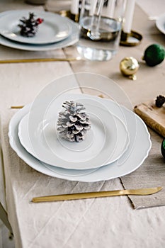 Christmas and New Year table setting in scandinavian style with rustic handmade details in natural and white tones.