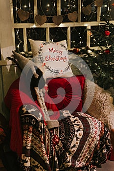 christmas and new year time. cozy soft armchair or easy chair with a comfy plaid and a red pad pillow