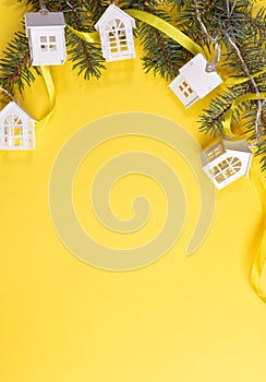 Christmas or New Year vertical background with green fir branches, Xmas lights white lodges on yellow with copy space.