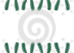 Christmas, New Year or winter white background with fir tree branches, small white snowflakes. Xmas and Happy New Year holiday