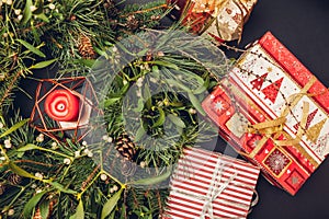 Christmas and New Year wreath made of fir, pine, mistletoe branches, cones with burning candle and gift boxes