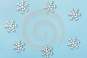 Christmas New Years background white snow flakes arranged in frame on blue backdrop. Minimalist elegant style for holiday poster