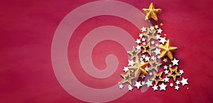 Christmas and New Years red background with Christmas Tree made of golden and wooden stars