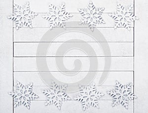 Christmas or New Years Snowflake Borders on White Wood Boards Background with copy space in the middle.  It`s horizontal but will