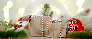 Christmas or Newyear gift box with tree branches and christmas decorations on wooden table, twinkling party lights bokeh