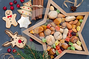 Christmas nuts and dried fruit mix in star-shaped bowl assortment of delicacies and cookies photo