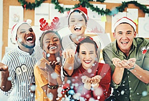 Christmas, office and business people blowing confetti and having fun together. Portrait, xmas party or group of happy