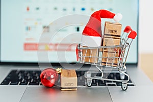 Christmas Online Shopping concept. Boxes with shopping cart on a laptop computer. Sale and discount during Christmas and New Year