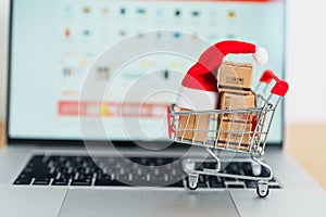 Christmas Online Shopping concept. Boxes with shopping cart on a laptop computer. Sale and discount during Christmas and New Year