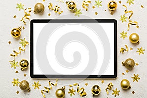 Christmas online shopping from home tablet pc with blank white display top view. Tablet with copy space on colored