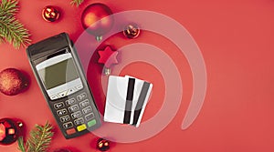 Christmas online shopping. Terminal with bank cards with Christmas decor on a red background. Baner. Copy space