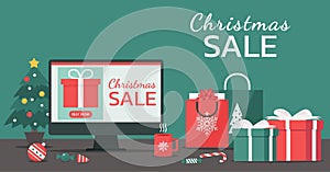 Christmas online shopping or winter holiday sale banner concept on a computer screen with shopping bags