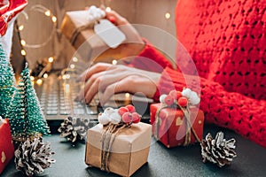 Christmas online shopping, work and education. New Year decorations on table. Woman with notebook computer at home. Winter