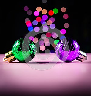 Christmas ornament ball green and purple with dark and colorful bokeh blur background